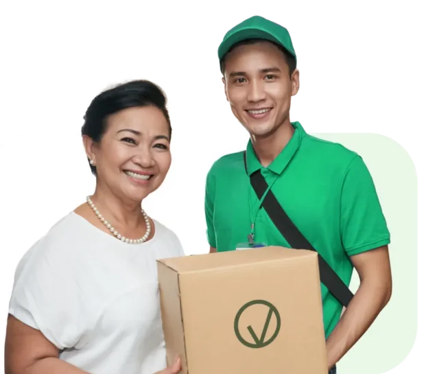 A woman stands next to a smiling delivery person in a green uniform, holding a cardboard box.